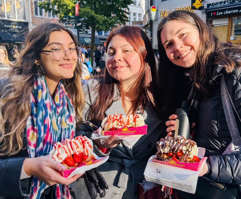 Three students posing with incredible desserts in their hands