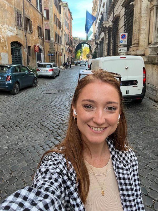 A woman taking a selfie in the middle of a Roman street