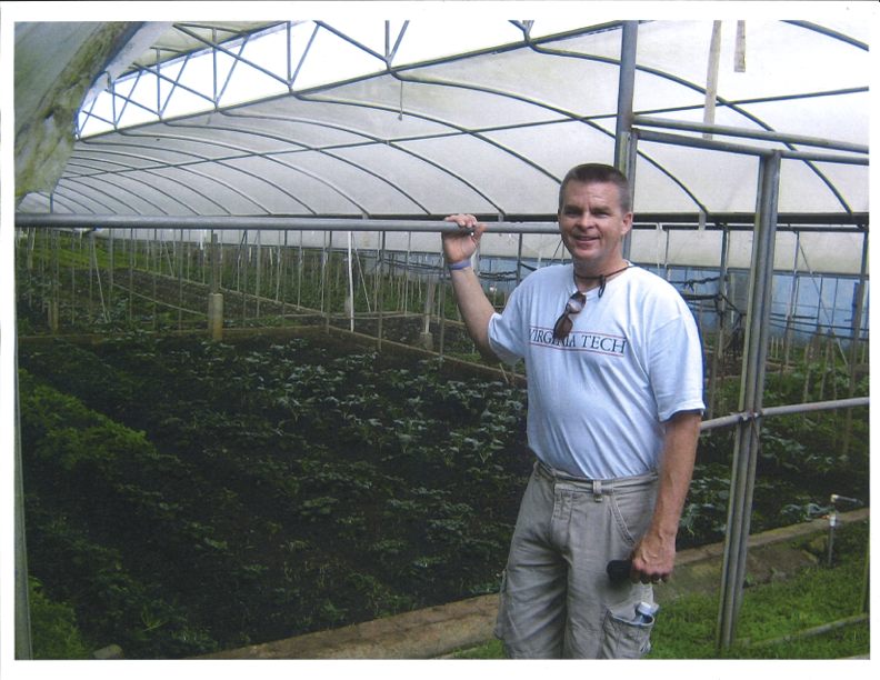 Ted Faulkner stands in front of crops at one of Virginia Tech's farms.
