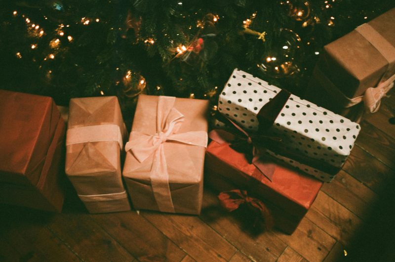 Holiday gifts wrapped under a tree 