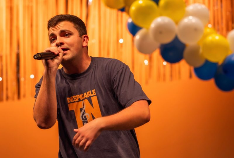 Jackson singing into a microphone on stage in front of a large amount of balloons.