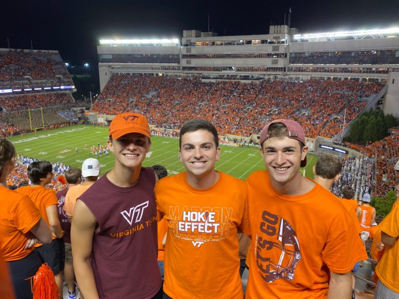 Jackson standing in the middle with two friends inside Lane Stadium.