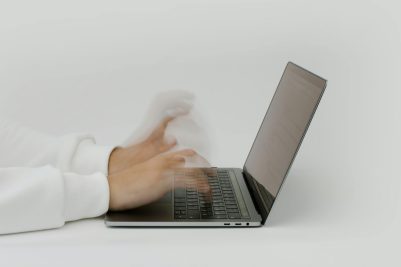 Hands typing on laptop keyboard 