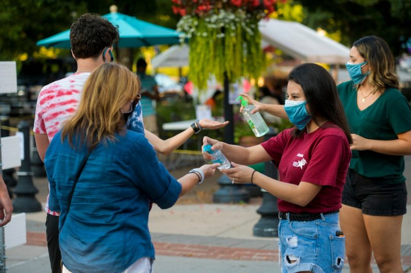 Fernanda Gutierrez and other members of the COVID Crushers group hand out masks, hand sanitizer, and resources in downtown Blacksburg