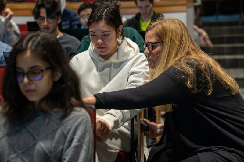 Margaret Ellis helping a student in a large-scale computer science class.