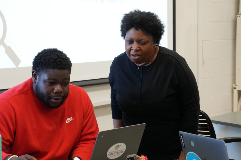 Student and teacher reviewing lesson on a laptop