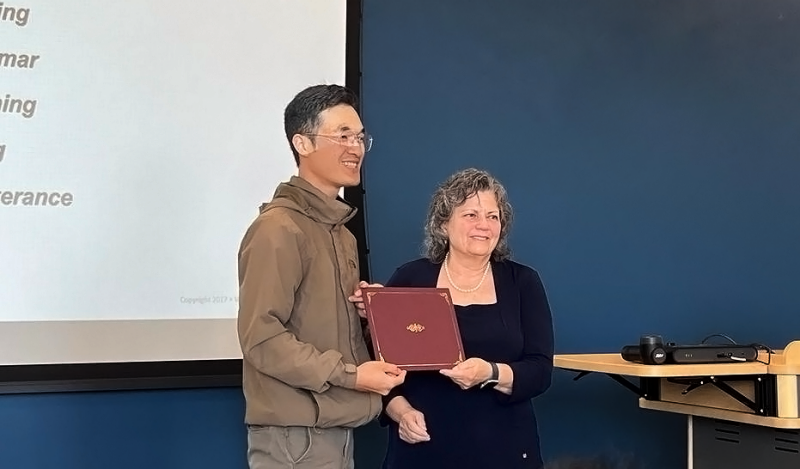 Nine (Paansri Paanwaris) stands with Bonnie Sumner accepting a certificate of completion for his LCI program