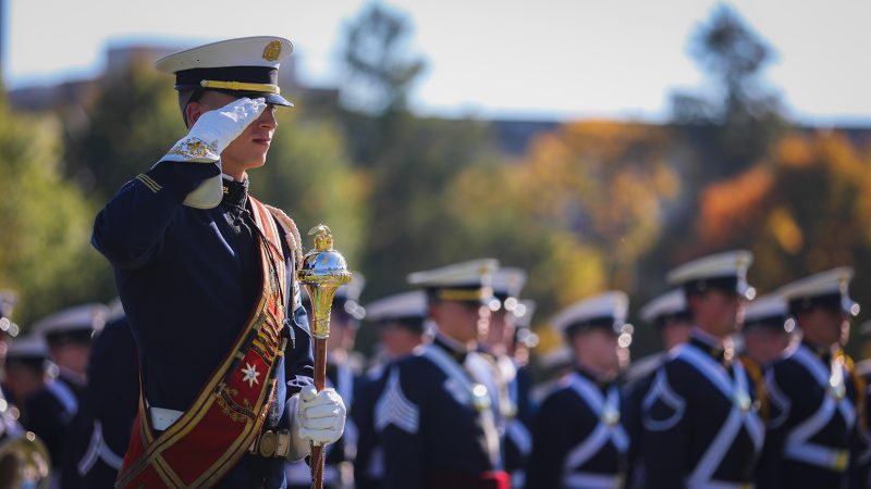 The drum major for the Highty-Tighties salutes during a parade on the Drillfield.