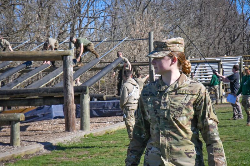 Longerbeam watches the obstacle course as cadets run down a slanted, elevated obstacle.