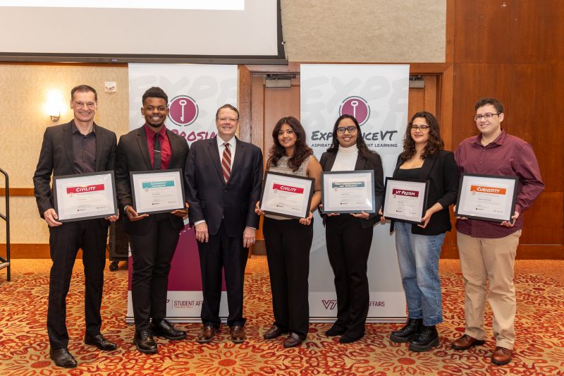 Five students and one faculty member hold their awards beside of Dean of Student Mark Sikes at the Aspire! Award celebration.