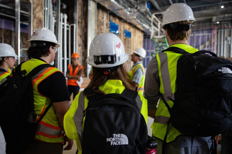 Students in hardhats tour building currently under construction.