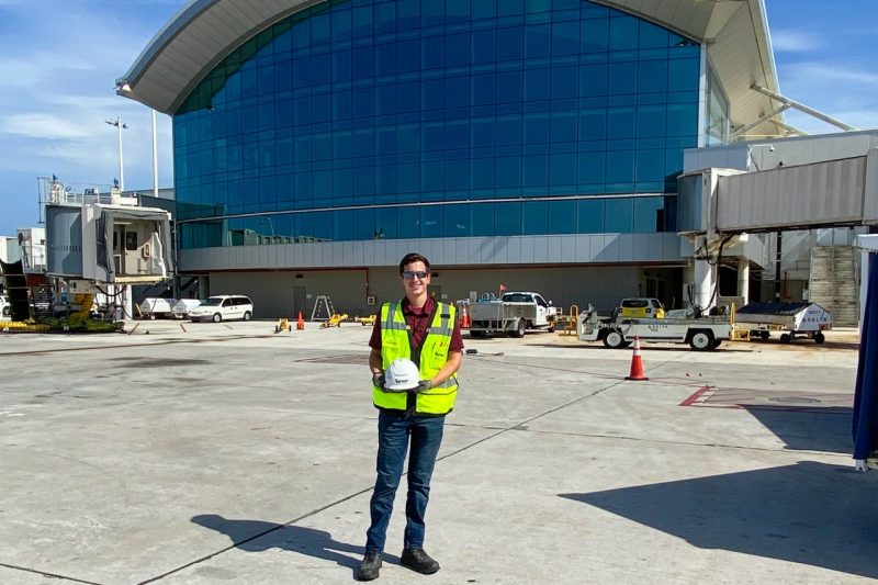 Man stands outside of airport.