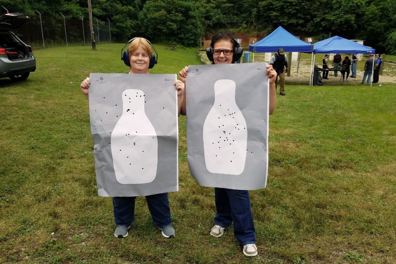 Robin Reynolds and Debbie Harris show off targets at the 2018 VT Employee Police Academy event.