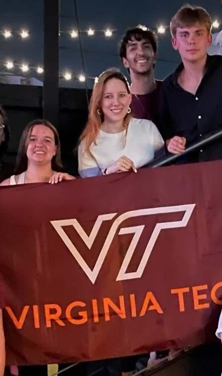 Four people holding a Virginia Tech flag