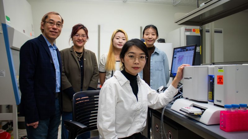 Five researchers posing together in a lab.