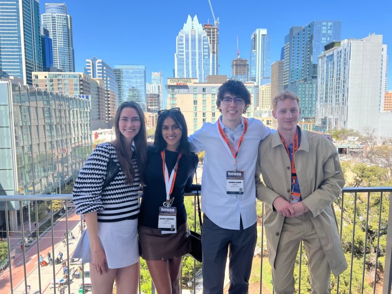 Four students stand on balcony in downtown Austin, Texas.