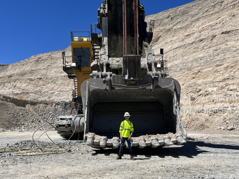 Reid Johnke standing in front of heavy machinery.