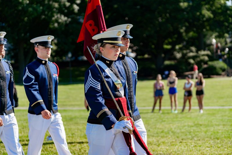 Stevens marches in front of Bravo Company in her dress uniform while carrying a sword.