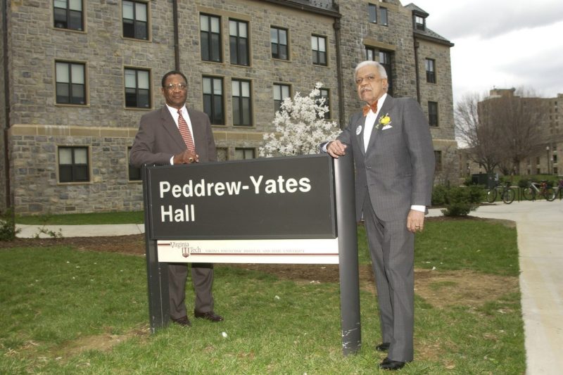 Peddrew-Yates Hall Two men stand in front of a building sign that reads Peddrew-Yates Hall.
