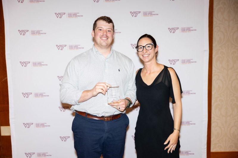 Man stands at left with an award woman stands at right.
