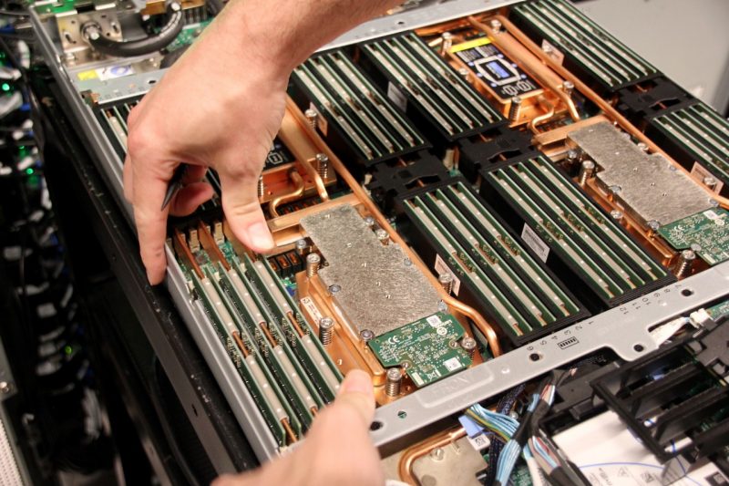 Hands point out a network of covered copper ducts in a computer