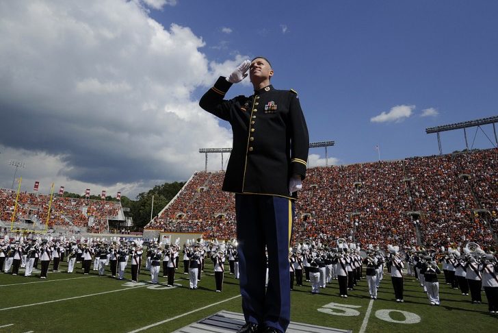 Lt. Col. Scott McKenzie salutes on Worsham Field as the Marching Virginias perform behind him.