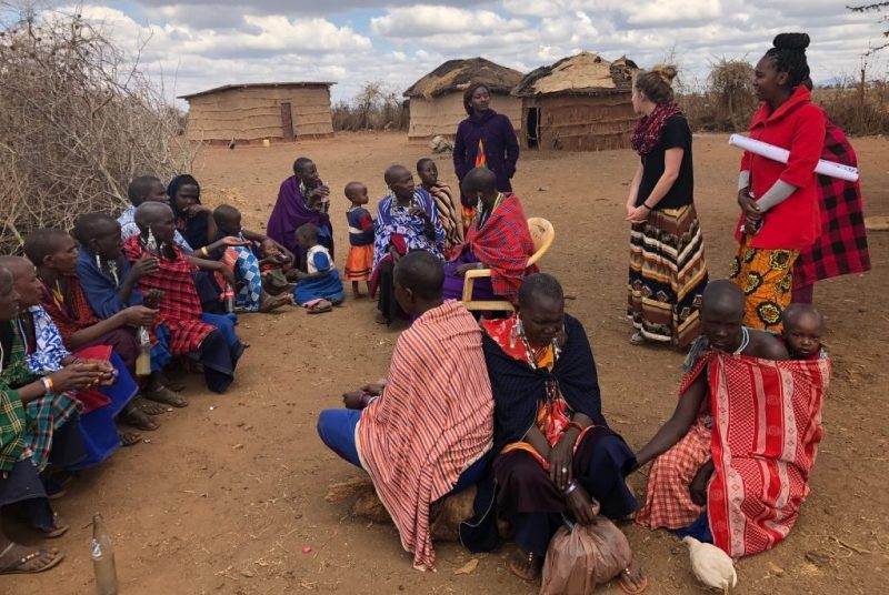 CNRE Baird Women Group Groups of people in brightly colored clothes have a conversation.