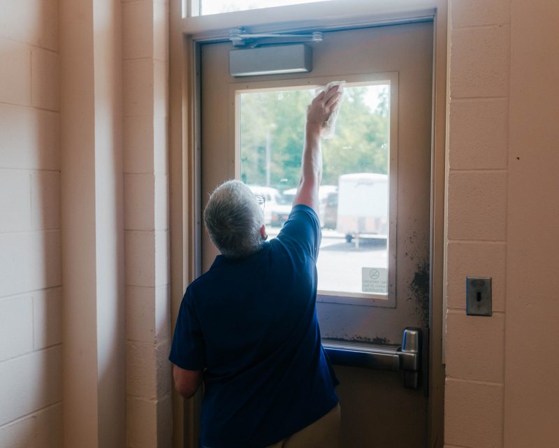 A Custodial Services employee cleans a window on Virginia Tech's Blacksburg campus.