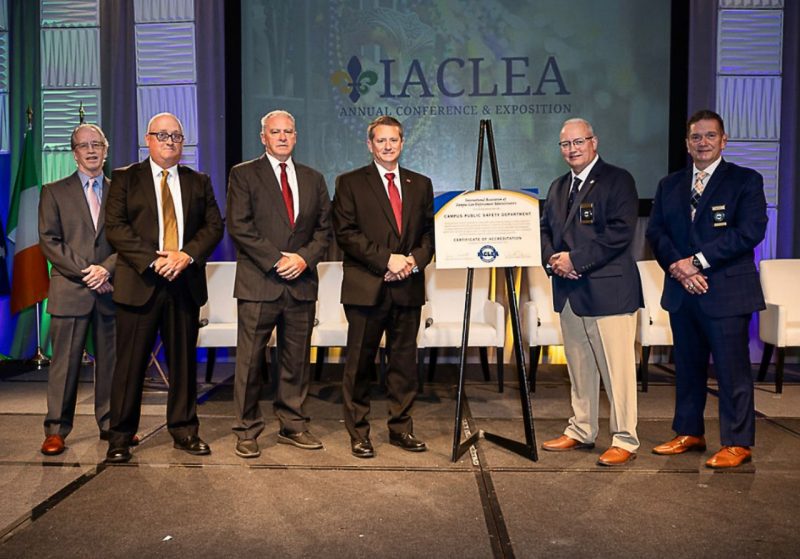 IACLEA Reaccrediation award ceremony with Chief Mac Babb, Cpl. John Tarter, and Officer Nigel Lee along with members of the ICLEA board