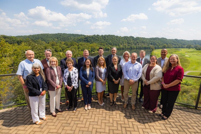 Virginia Tech Board of Visitors - August 2024 Members of the university's board of visitors stand on a balcony overlooking a golf course.