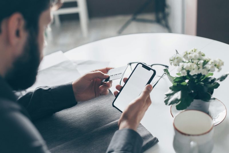 man holding phone and credit card