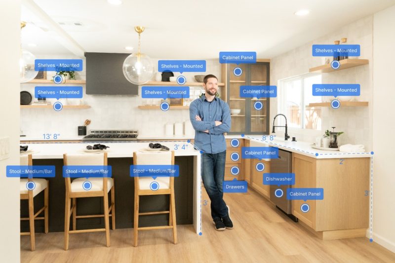 ECE Alum Zach Rattner stands in a kitchen with blue bubbles all around him. The bubbles contain different words, highlighting different objects around the space. This is a demonstration of the Yembo tech.