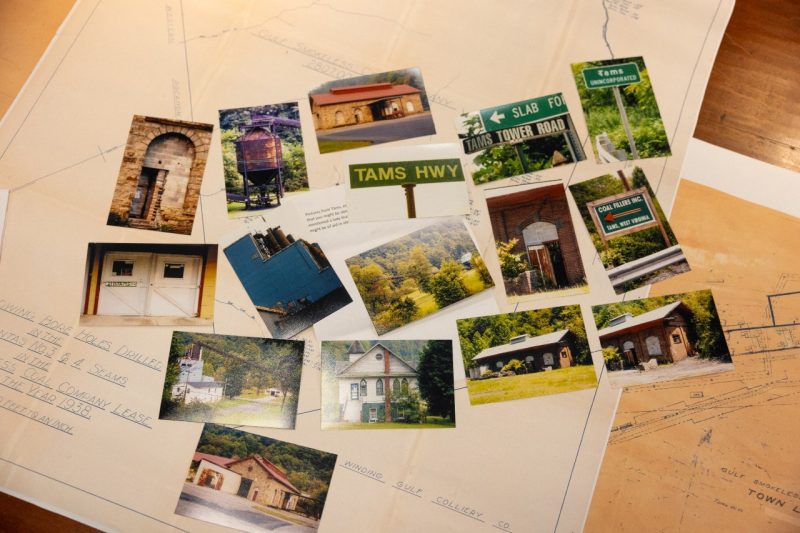 Various photos are laid out on a table. Many of them depict signs and town buildings.