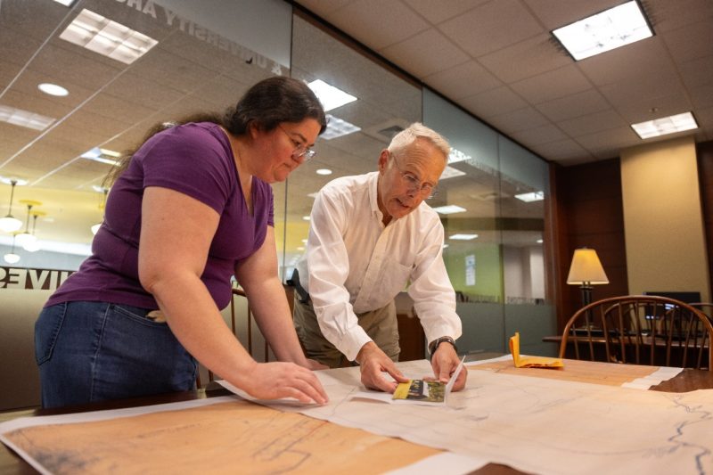 (From left) Laura Carruba and John Woodhouse talk about pictures of the town of Tams.