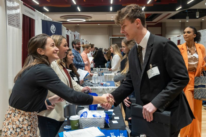 people shaking hands over an information table