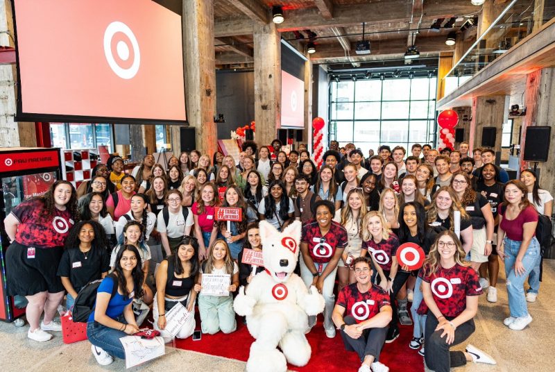 Target Interns A large group of people pose for a group photo with the Target mascot, a furry dog
