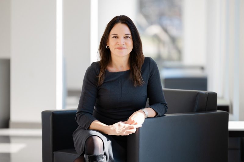 Headshot of Pascha Gerni, Managing Director of Business and Administration, wearing a dark dress in beside a window.