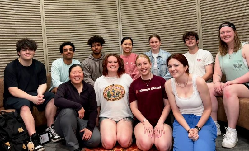 A group of eleven participants and facilitators in one of The Connection Program's pilot programs at Virginia Tech sit in two rows against a tan wall, smiling.