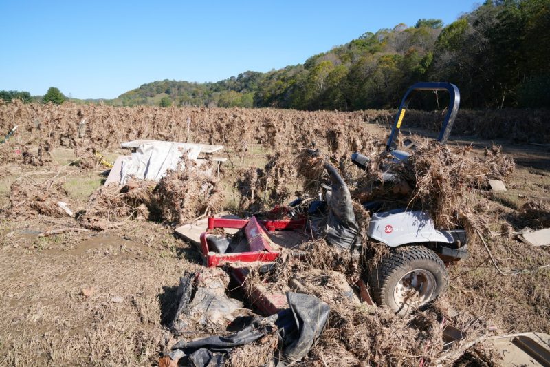 A tractor lies in a field covered with dead crops.