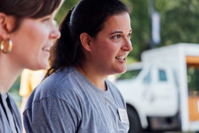 A close-up of two women talking to an unseen third person.