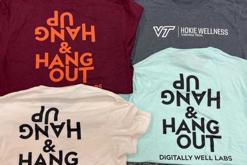 Colorful T-shirts reading "Hang Up and Hang Out: Digitally Well Labs," and "Hokie Wellness," lie flat in a mosaic pattern.