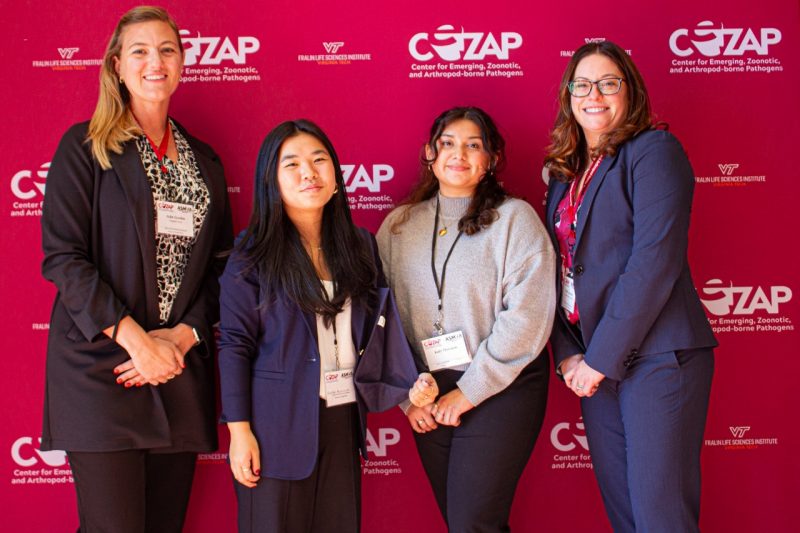 Gerdes Conference Group 2024 Photo of four women dressed professionally, posed and smiling at the camera in front of a pink wall with the CeZAP logo printed on it in white.