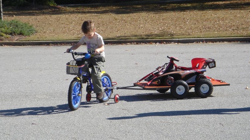 John Bobbitt IV pulling the trailer he designed behind his bicycle as a child. Photo courtesy of John Bobbitt III.
