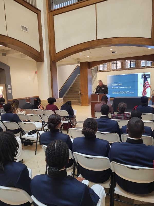 Dwayne R. Edwards, Brigadier General in the U.S. Army (Ret.) and Commandant of the Corps of Cadets at Ceremony for Lindsay Cherry '58 Saber and Ring Donation A man in an Army uniform stands at a podium with a screen behind him and an audience in rows of chairs in front of him.