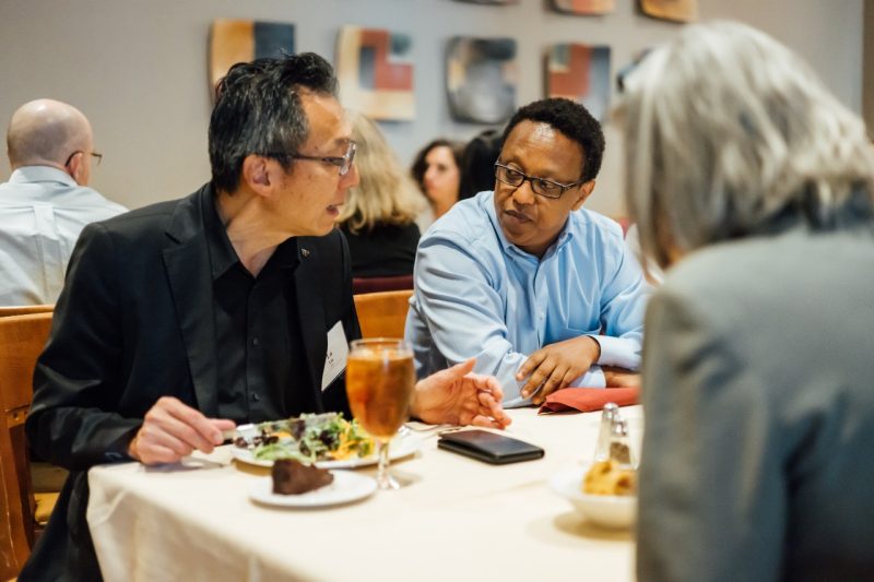 Dean Lu Liu talks to a faculty member over lunch.