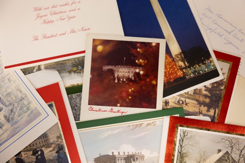 Presidential holiday cards send to Genevieve Herrell are displayed on a table.