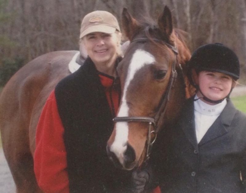 Cecelia Ivey Cecelia Ivey (at right) in riding gear, standing with a horse and another person.