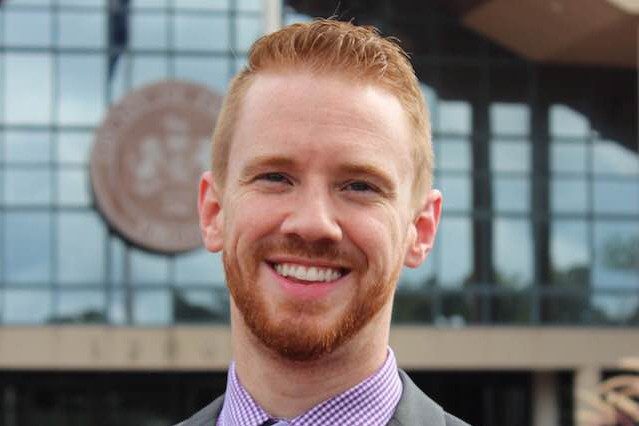 Headshot of man wearing a blazer and tie