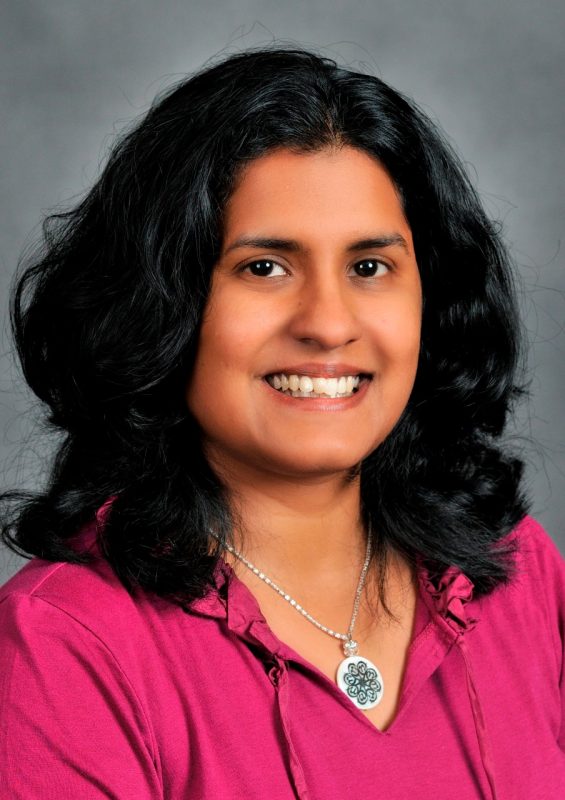 Headshot photo of woman wearing pink shirt.