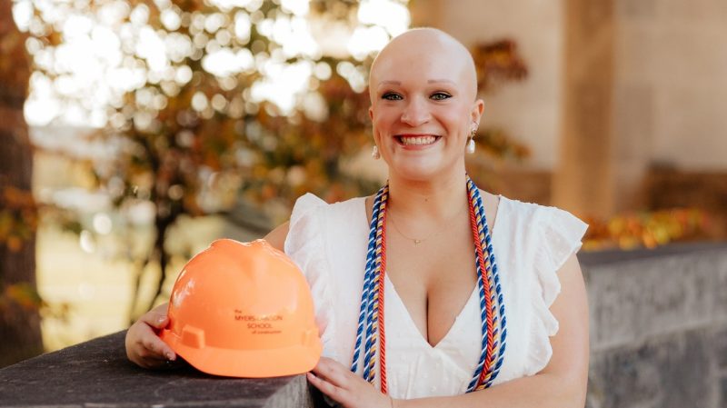 Natalia Ayala-Torres. Photo courtesy of Grace Saville Photography. Woman stands at Virginia Tech Pylons with an orange hardhat.